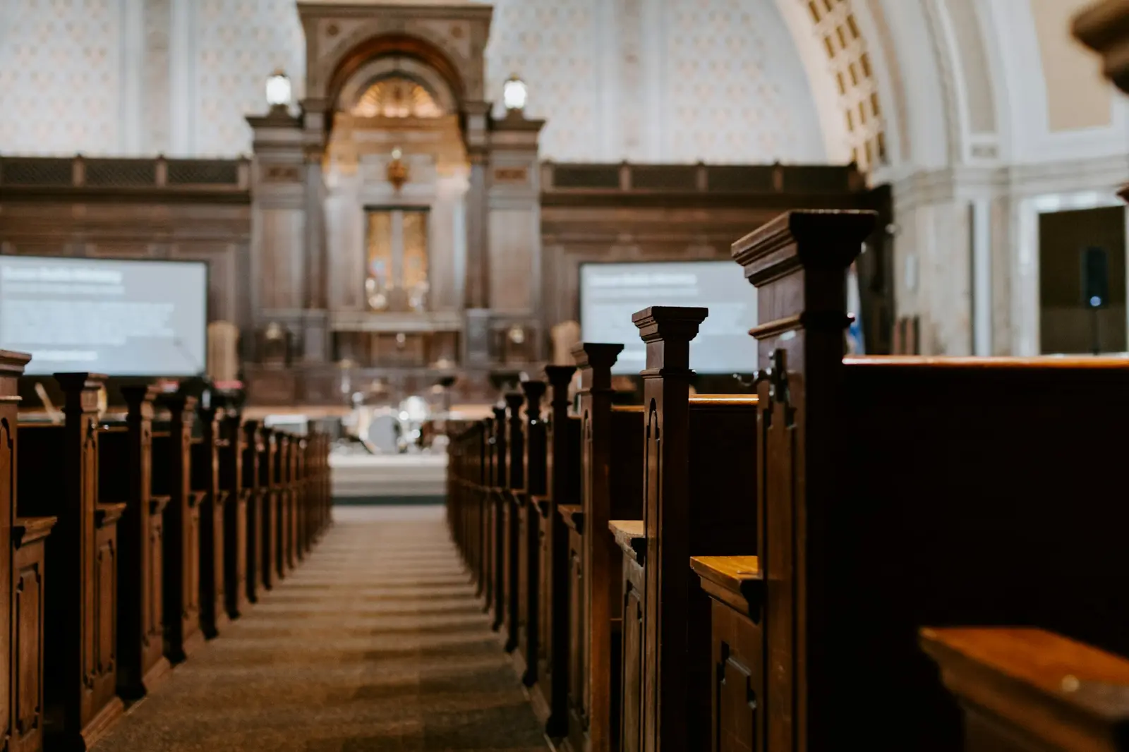 Wooden pews along the center aisle of a sanctuary