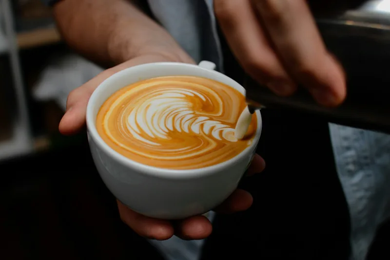 Latte art on a fresh coffee at the counter