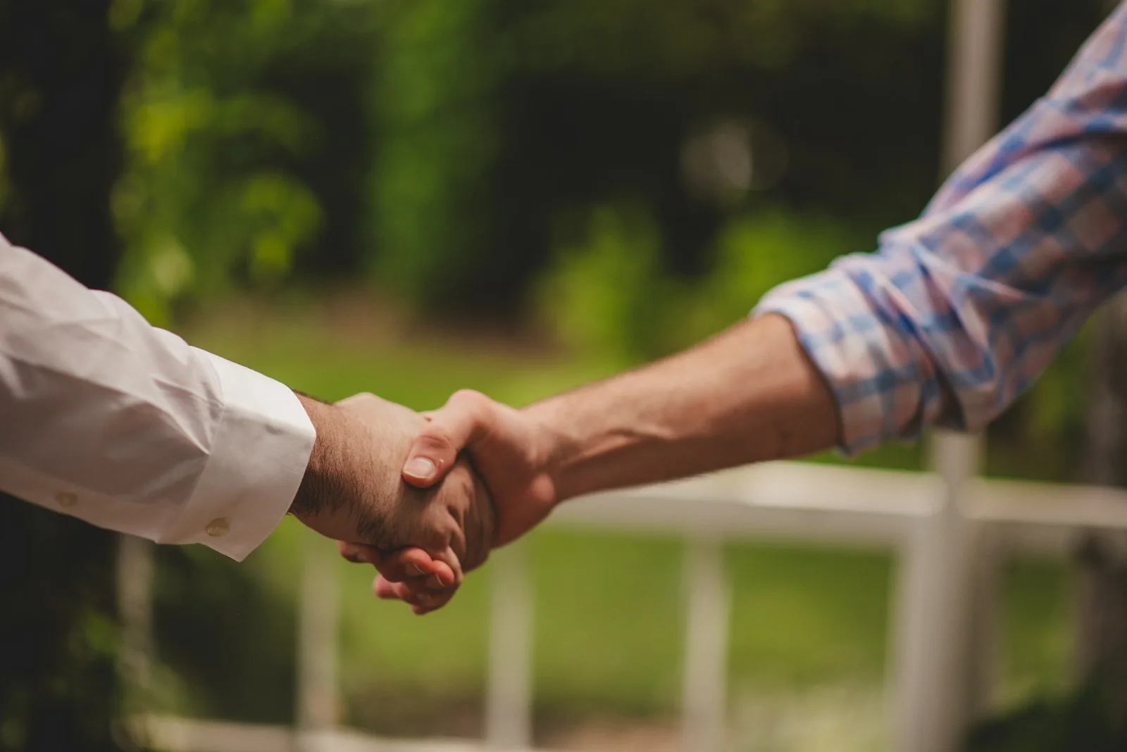Two people shaking hands outdoors