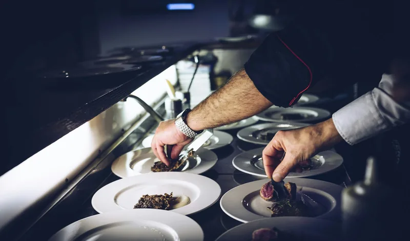 Plating the main course for a seated dinner