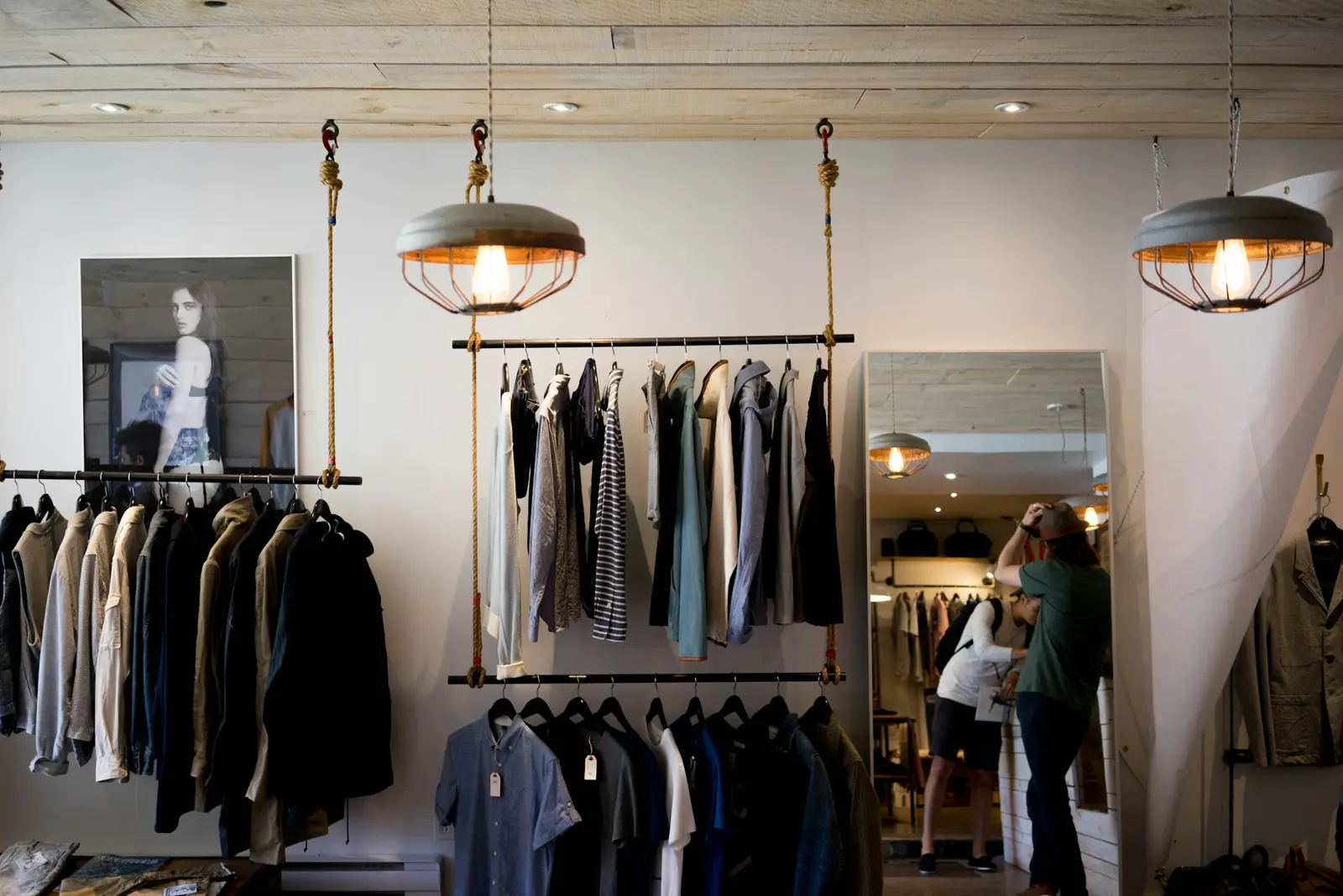 Boutique with clothing on hanging rails under warm lamps